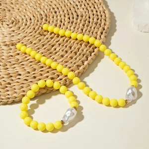 Détail d'un ensemble de bijoux en perles jaunes avec perles baroques et fermoir doré