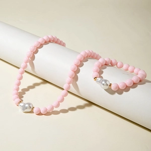 Gros plan sur l'ensemble bijoux en perles roses avec perles baroques sur présentoir