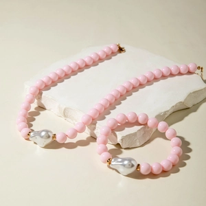 Vue détaillée de l'ensemble de bijoux en perles roses avec une perle baroque blanche