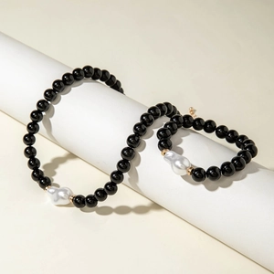 Détail d'un collier de perles noires avec perles baroques sur un support de colonne
