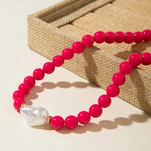 Détail du collier de perles rose fushia avec grande perle baroque et séparateurs dorés