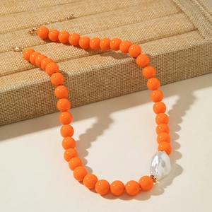 Vue détaillée du collier de perles oranges avec perle baroque et fermoir doré chic