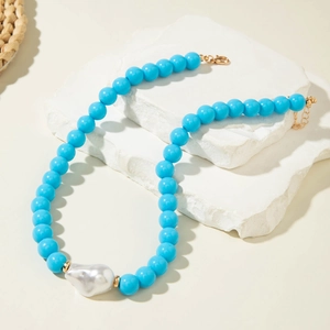 Détail du collier de perles bleues avec perle baroque argentée et fermoir doré réglable