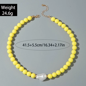 Détail du collier à perles jaunes avec une perle baroque blanche et fermoir doré