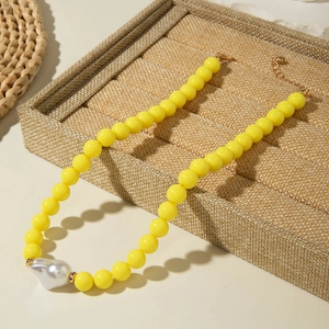 Détail du collier de perles jaunes avec perle baroque et fermoir mousqueton doré