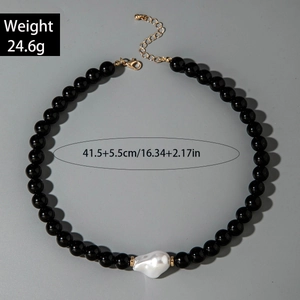 Détail du collier de perles noires brillantes avec une grande perle baroque blanche