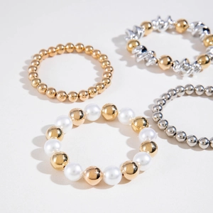Set of four gold and silver beaded bracelets with pearls and textured twisted links