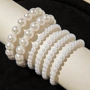 Detail of 5pcs faux pearl bracelet set with heart charms on professional black velvet stand