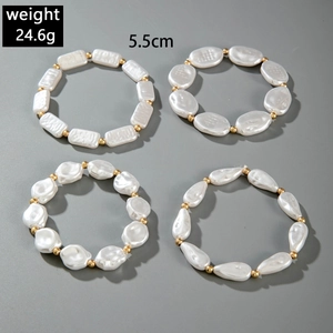 Detail view of 4-piece set featuring white baroque pearls and golden spacer beads