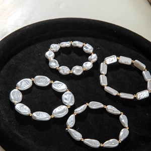 Detail view of 4-piece pearl bracelet set with baroque and gold beads on black velvet