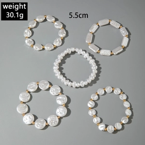 Detailed view of a 5-piece faux pearl bracelet set with gold accent beads in a circle