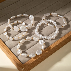 Close-up of four baroque pearl bracelets with golden spacers on a jewelry tray