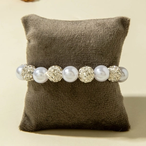 Detail of luxury beaded bracelet with white pearls and sparkling diamond-studded balls