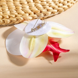 Close-up of artificial orchid brooch back showing metal pin and silk petal texture