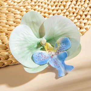 Detailed macro view of realistic faux butterfly orchid flower head with delicate fabric texture