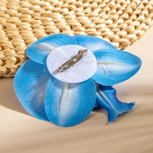 Detail view of the blue orchid brooch backing with a secure metal pin and felt base