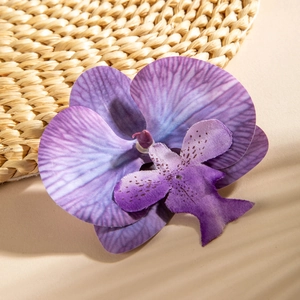Detailed view of a purple artificial orchid head with realistic silk fabric texture
