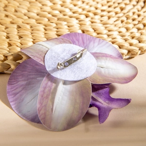 Detail view of the orchid brooch back showing white felt base and metal safety pin