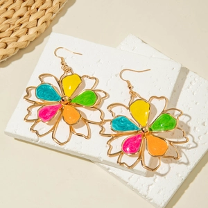 Detail of colorful enamel flower earrings with golden edges on white stone displays