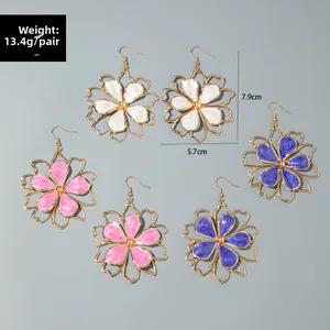 Detailed view of large flower earrings in white, pink, and purple enamel gold plating