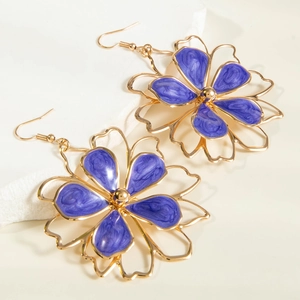 Macro view of purple enamel flower earrings with gold metal frames and textured finish
