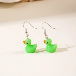 Close-up of cute green resin duck earrings with silver metal hooks on a white surface