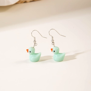 Detailed view of light blue resin duck earrings with silver hooks on a clean surface