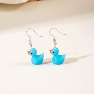 Detail shot of bright blue resin duck earrings with glossy finish and silver hooks