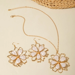 Golden flower jewelry set with white enamel petals including necklace and drop earrings