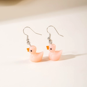 Detailed view of pink resin duck earrings with silver hooks on a neutral background