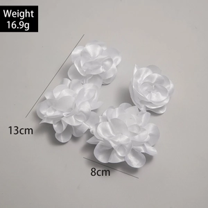 Detail view of large white fabric rose earrings with dimensions 13cm and weight 16.9g