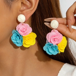 Detailed view of colorful fabric flower earrings featuring pink, blue and yellow roses