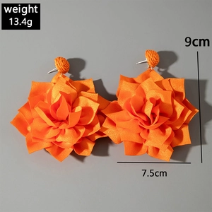 Detail view of large orange fabric flower earrings showing 9cm height and 7.5cm width