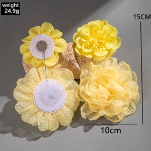 Detail of yellow fabric flower accessories with sizes 10cm and 15cm on wood bark
