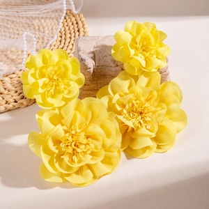 Yellow fabric flower earrings shown on a woven mat with natural stones and pearls