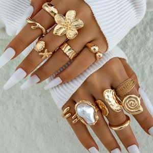 Golden alloy ring set featuring starfish, shells, flowers, and oversized faux pearl