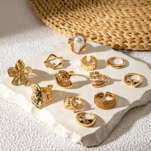 Detail of 11-piece gold alloy ring set featuring baroque pearl, starfish and shell designs