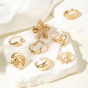 Golden 7-piece ring set with starfish, seashell, and flower designs on white stone