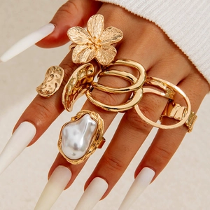 Gold starfish flower ring set with pearls and hammered texture on female hand