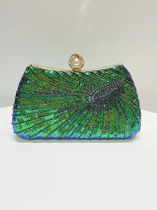 Detail of green sequin evening bag featuring a pearl clasp and gold metal trim