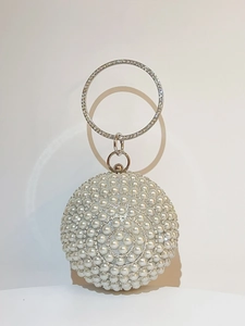 Close-up of pearl evening clutch with rhinestone handle and crystal beaded finish