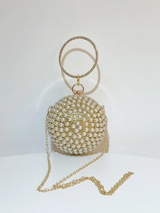 Detailed view of spherical pearl evening bag with rhinestone ring handle and golden chain