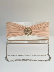 Détail de la pochette de soirée en satin champagne avec fleur en strass et chaîne