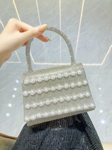 Detail of silver rhinestone evening bag with elegant pearl rows and crystal top handle
