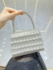 Detail of silver evening bag with sparkling rhinestones and elegant faux pearl rows