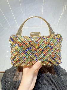 Dettaglio di pochette da sera di lusso con strass colorati e manico dorato