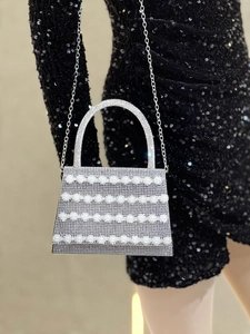 Close-up of silver rhinestone evening bag with pearls and chain strap for parties