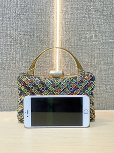 Dettaglio di una lussuosa borsa da sera con cristalli colorati e manico dorato