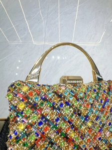 Dettaglio macro di cristalli colorati e manico dorato su questa lussuosa borsa da sera
