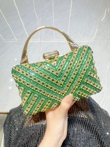 Dettaglio della lussuosa borsa da sera con cristalli verdi e manico in metallo dorato